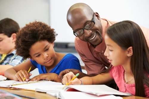 Teacher helping learners with classroom work