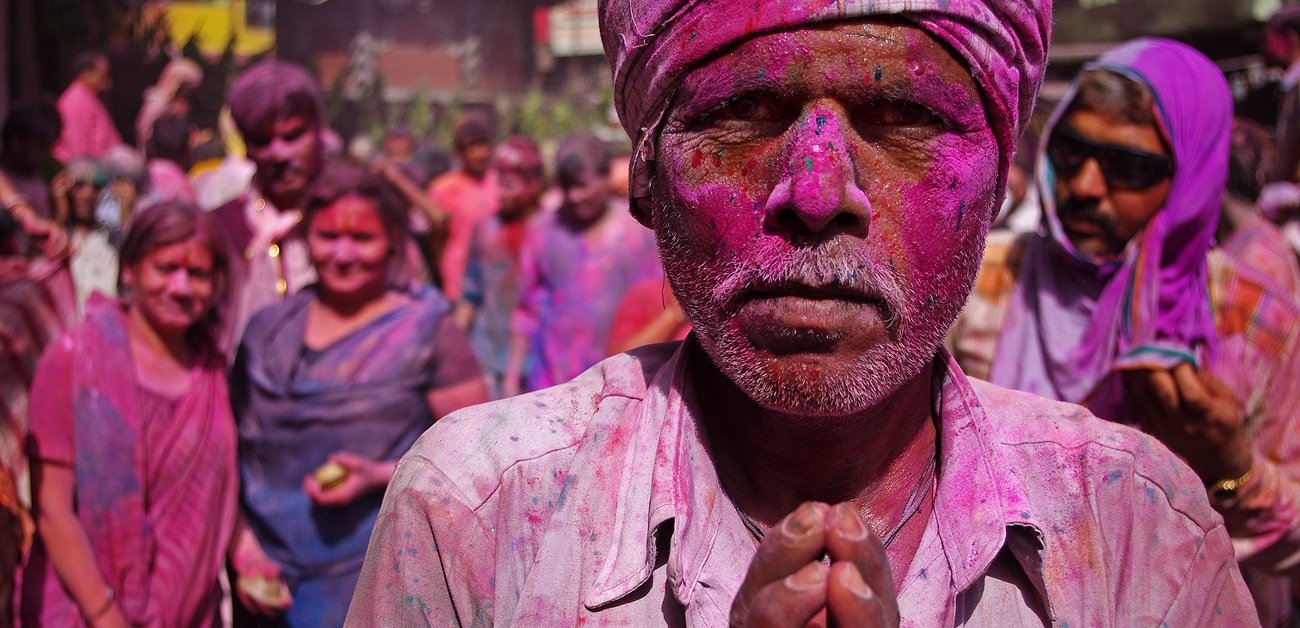 Worshipper covered in bright colors during the Holi festival