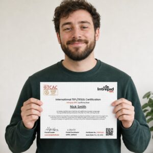 Real Intrepid TEFL student holding his IntrepidTEFL 120-hour TEFL certificate smiling with pride